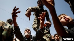 A man who fled eastern Ghouta gestures as he receives aid from Russian forces at a shelter in Adra, near Damascus, Syria, March 20, 2018.