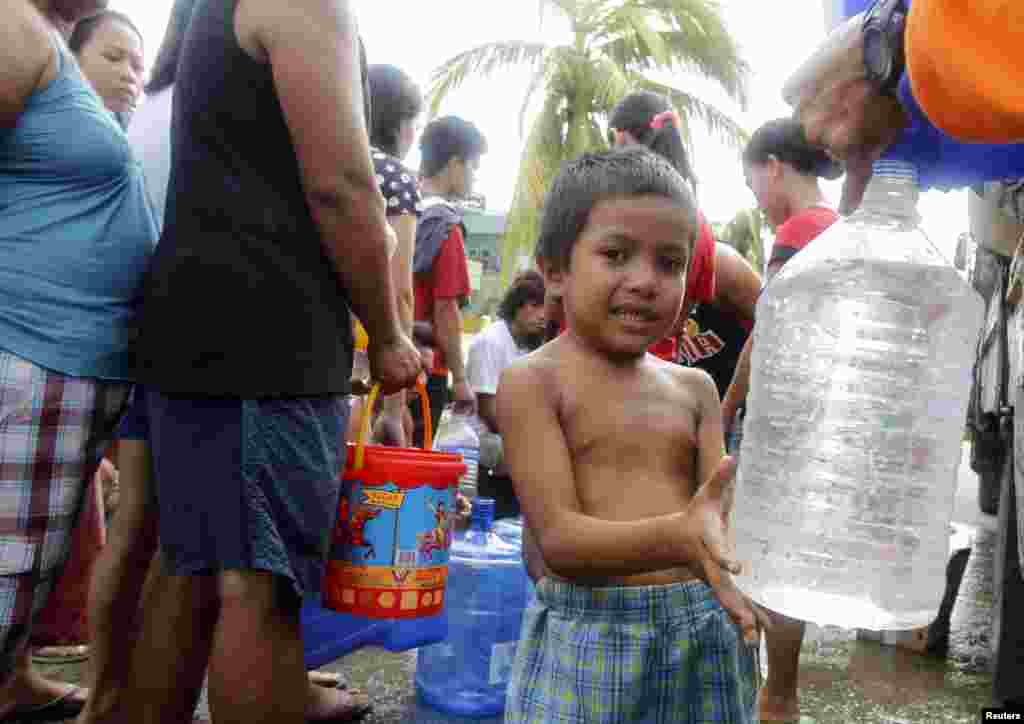 A boy fills a plastic bottle with water in Tacloban city, central Philippines, Nov. 11, 2013. 