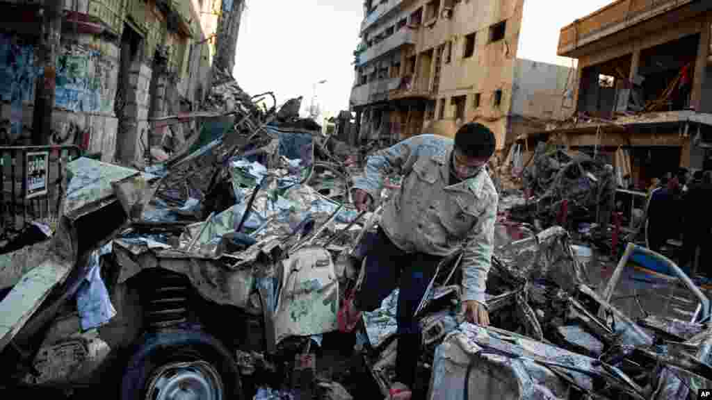 An Egyptian man makes his way through rubble at the scene of an explosion at a police headquarters building in the Nile Delta city of Mansoura, Egypt, Dec. 24, 2013.