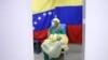 Con el telón de fondo de una bandera nacional, un médico espera recibir una dosis de la vacuna rusa COVID-19 Sputnik V en el hospital público Ana Francisca Pérez de León II en Caracas, el 19 de febrero de 2021.