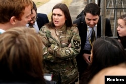 In a borrowed U.S. Army jacket to keep warm, White House press secretary Sarah Huckabee Sanders updates reporters on President Donald Trump's failed attempt, preempted by weather, to visit Observation Post Ouellette along the Demilitarized Zone (DMZ) in the truce village of Panmunjom dividing North Korea and South Korea outside Seoul, South Korea, Nov. 8, 2017