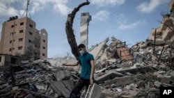 A Palestinian man inspects the damage of a six-story building which was destroyed by an early morning Israeli airstrike, in Gaza City, May 18, 2021.