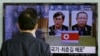 지난 3월 한국 서울역에서 한 시민이 북한 당국에 체포돼 억류 중인 한국 국민 김국기(왼쪽)씨와 최춘길 씨에 관한 TV 보도를 시청하고 있다. (자료사진)