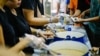 Staff and volunteers hand out meals at the Pit Stop Community Café in Kuala Lumpur, Malaysia. (Courtesy - Pit Stop Community Café)