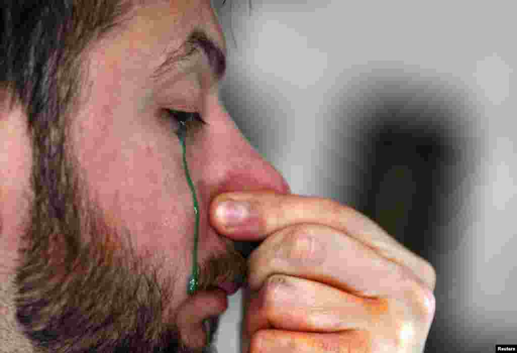 Seniman Leandro Granato melelehkan cat dari matanya ke atas kanvas di studionya di kota Alejandro Korn di Buenos Aires, Argentina, 10 Oktober 2013. Granato melukis dengan teknik unik yang terdiri dari memasukkan cat melalui hidung dan menyemprotkan keluar melalui matanya ke atas kanvas.