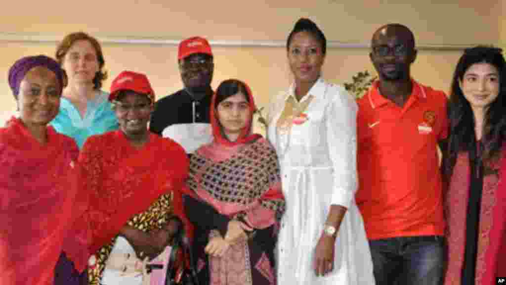 Malala Yousafzai qui a survécu à une fusillade des Talibans qui lui en voulaient pour son combat pour l’éducation de jeunes filles, pose pour une photo avec des organisateurs de la campagne Ramenez-Nous Nos Filles à Abudja, Nigeria, dimanche le 13 juillet 2014. (AP Photo/Olamikan Gbemiga)