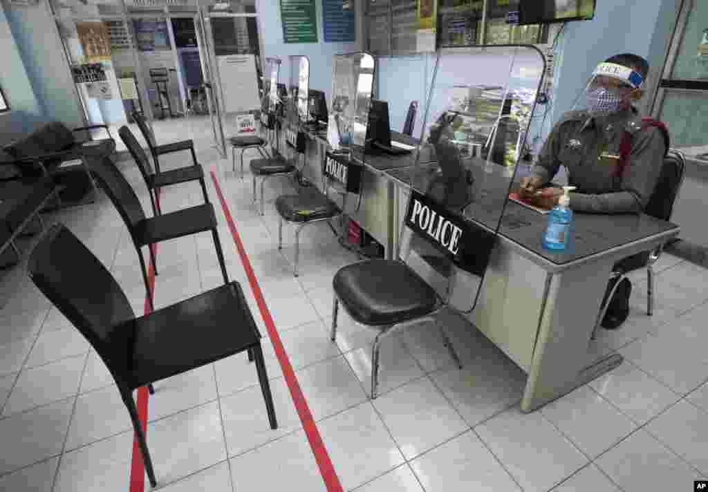 La policía usa escudos antidisturbios para practicar el distanciamiento social, para ayudar a frenar la propagación del coronavirus en la estación de policía de Tha Phra, en Tailandia.