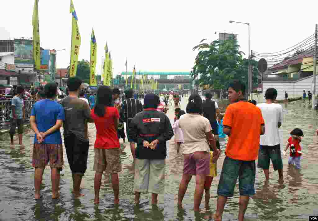 Residents of Kampung Melayu look at the flood waters on a bridge, South Jakarta, Indonesia, January 17, 2013. (K. Lamb/VOA)