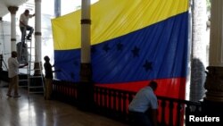 Trabjadores cuelgan una enorme bandera venezolana frente a la sala de sesioens en el edificio de la Asamblea Nacional en Caracas, Venezuela, el 5 de enero de 2018.