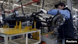 Seorang pekerja di pabrik mobil elektronik Beijing Electric Vehicle, yang didanai oleh BAIC Group, di Beijing, China (18/1). (Reuters/Kim Kyung-Hoon)