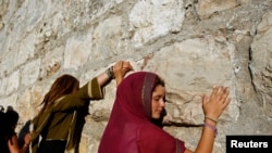 Une femme touche le mur des Lamentations, à Jérusalem, le 21 juin 2009. (Photo: REUTERS/Ammar Awad)