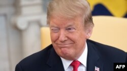 Presiden AS Donald Trump tersenyum saat rapat di Ruang Oval Gedung Putih di Washington, 25 Maret 2019. 