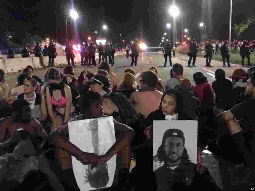 Polisi berjaga-jaga dekat para demonstran yang memblokir jalan layang di St. Paul, Minnesota (9/7). (AP Photo/Joe Danborn)