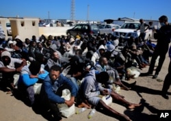 FILE - African illegal migrants wait to receive medial assistance after being rescued by coast guards, in Tripoli, Libya, April 11, 2016.