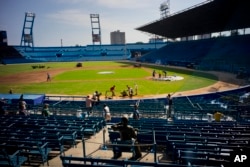 People work near a statue of Cuban baseball fan and entertainer Armando Luis Torres Torres at the Latinoamericano stadium, March 16, 2016. A friendly game will be played on March 22 between Cuba's national team and the Tampa Bay Rays in Havana.