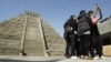 Students take pictures of themselves in front of a mock pyramid during the countdown to when many believe the Mayan people predicted the end of the world, Friday, Dec. 21, 2012, in Taichung, southern Taiwan.