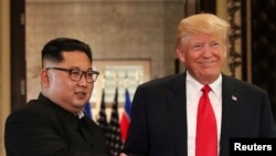特朗普總統今年6月在新加坡峰會上簽署了一系列協議後與金正恩握手。