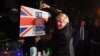Archivo - El primer ministro británico Boris Johnson posa con un almádena tras golpear un cartel que dice "Hagan el Brexit" en South Benfleet, Gran Bretaña, el 11 de diciembre de 2019.