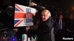 Archivo - El primer ministro británico Boris Johnson posa con un almádena tras golpear un cartel que dice "Hagan el Brexit" en South Benfleet, Gran Bretaña, el 11 de diciembre de 2019.