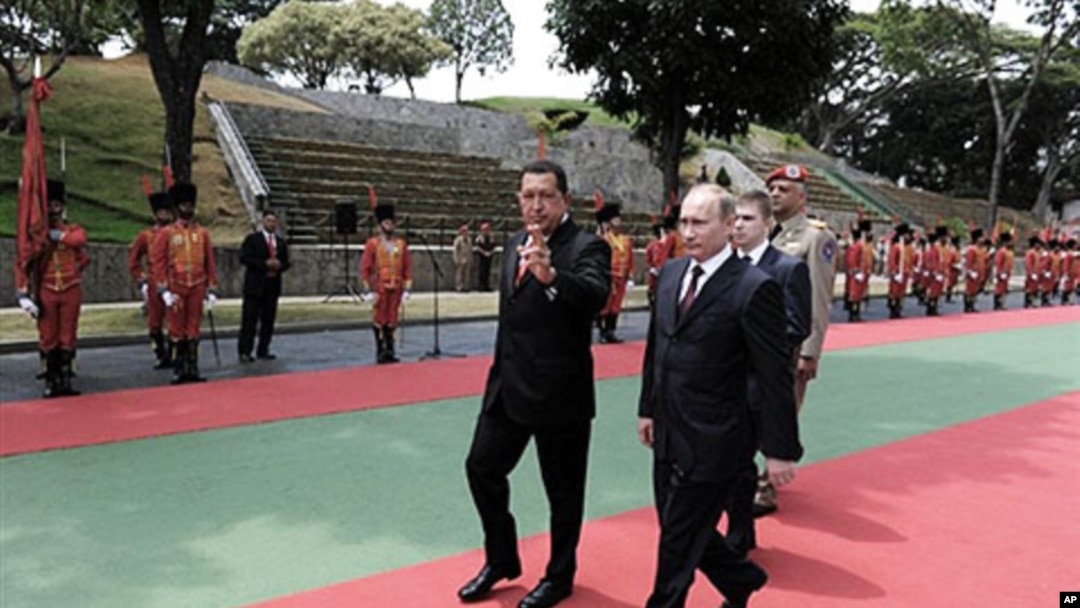 Venezuelan President Hugo Chavez (L) and Russian Prime Minister Vladimir Putin receive military honors at the Presidential palace Miraflores in Caracas, 02 Apr 2010