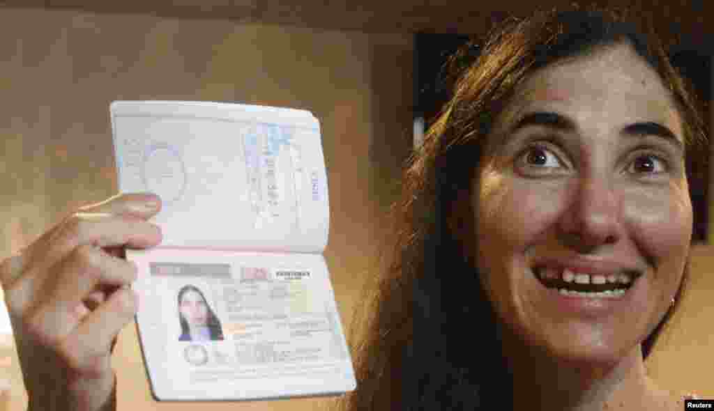 La bloguera cubana Yoani Sánchez posa junto a su pasaporte al llegar al aeropuerto internacional Guararapes en Recife, Brasil proveniente de La Habana, Cuba, el lunes 18 de febrero.