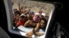 Desperate villagers rush to a window of a U.S. Navy Seahawk helicopter as crewmen deliver aid in an emergency drop in San Jose, Philippines, Nov. 18, 2013.
