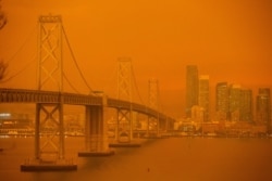 FILE - The San Francisco Bay Bridge and city skyline are obscured in orange smoke and haze as seen from Treasure Island in San Francisco, Calif., Sep. 9, 2020.