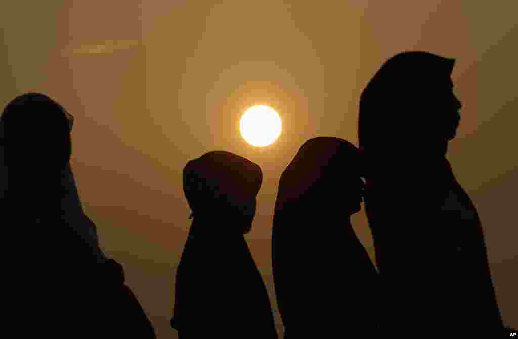 Indonesian Muslim women walk before the Eid al-Fitr prayer that marks the end of Ramadan, Jakarta, August 8, 2013.