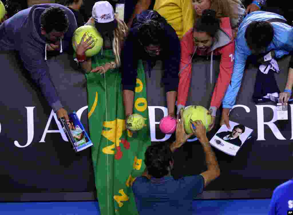 Petenis Swiss, Roger Federer memberikan tanda-tangan kepada para fans setelah menang melawan Andy Murray pada turnamen Australia Terbuka, di kota Melbourne.