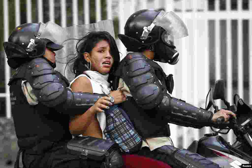 Polisi menahan seorang pengunjuk rasa anti-pemerintah dalam protes terhadap pemerintahan Presiden Nicolas Maduro di Caracas, Venezuela.
