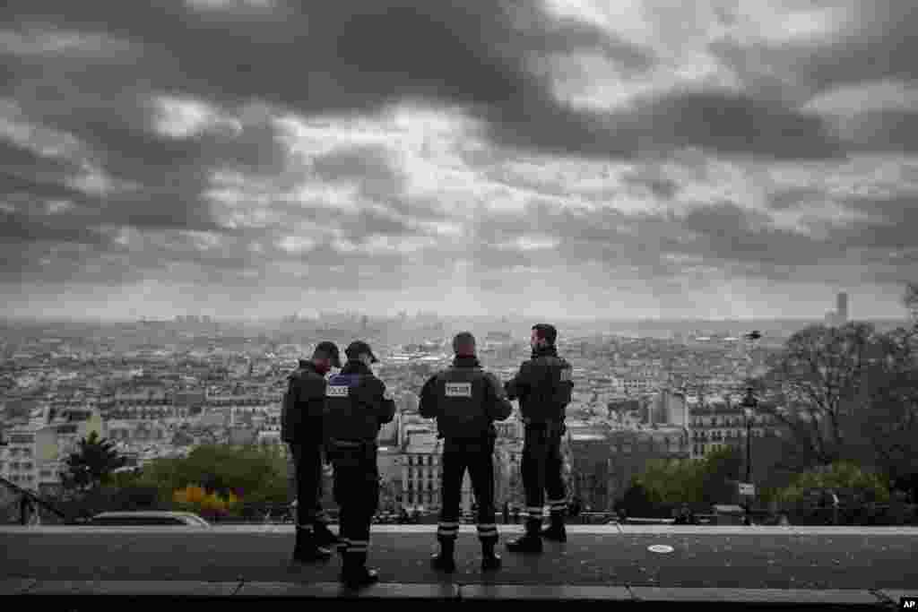 Paris is seen as French Police officers stand on guard near the church of Sacre Coeur, on top of the Montmartre hill, in Paris, Nov. 18, 2015.