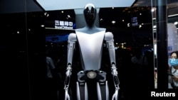 资料照片:特斯拉机器人于2023年7月6日在中国上海举行的世界人工智能大会(WAIC)上展示。官媒新华社10月2日表示将出台支持政策,持续推动中国智能网联汽车产业高质量发展。中国智能汽车行业面临着地缘政治阻力以及来自特斯拉等西方同行在改进技术方面的激烈竞争。 (路透社图片)