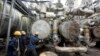 FILE - Workers try to tie a pipe at an oil refinery in Port Harcourt, Nigeria, Sept. 16, 2015. One of two state refineries in Port Harcourt will resume refining of crude oil in early August 2024, officials say.