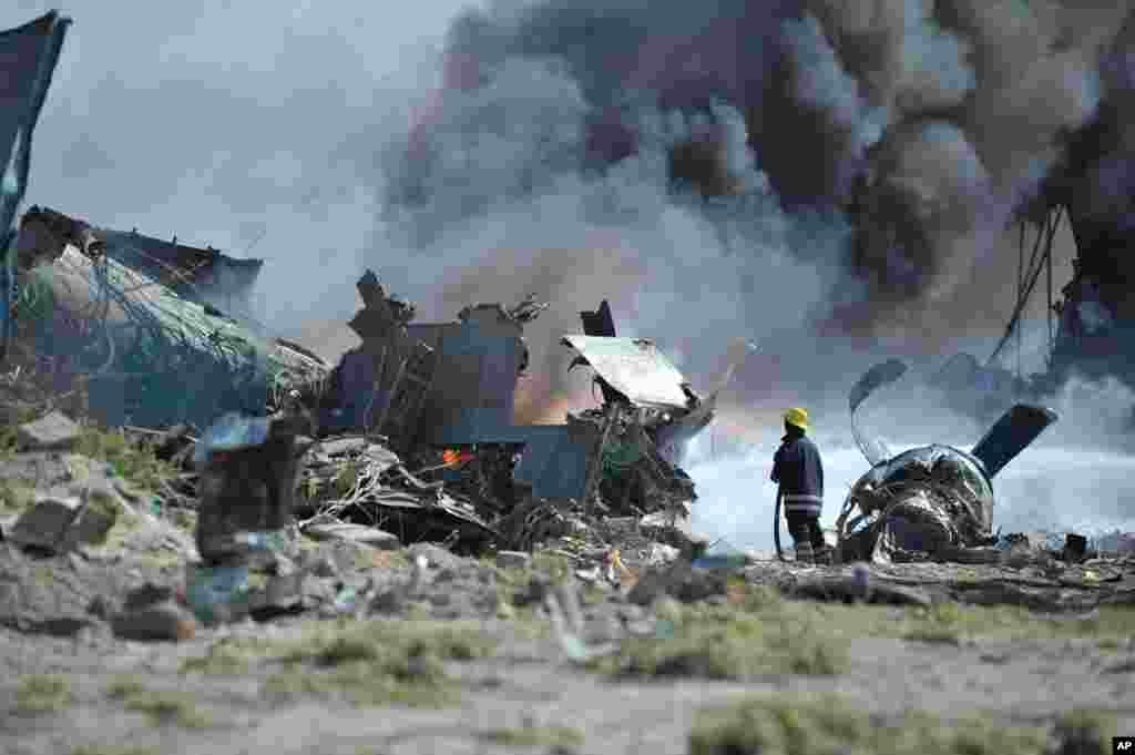 Regu pemadam kebakaran berusaha memadamkan api di Bandara Internasional Mogadishu Aden Adde di Somalia setelah sebuah pesawat milik Angkatan Udara Ethiopia jatuh saat mendarat.