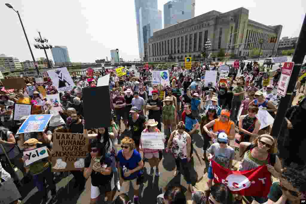 People pause during a demonstration and march on Market Street in Philadelphia, April 29, 2017. Thousands of people gathered across the country to march in protest of President Donald Trump's environmental policies, which have included rolling back restrictions on mining, oil drilling and greenhouse gas emissions at coal-fired power plants.