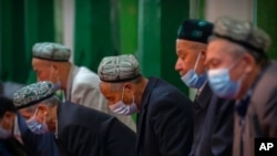 Aba Uyghurs hamwe n'ayandi moko bariko barasengaku musigiti w'i Kashgar mu burengero bwa Xinjiang.