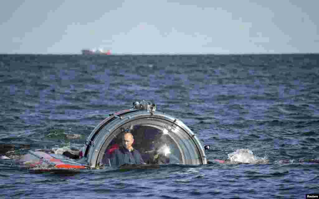 Presiden Rusia Vladimir Putin (kiri) terlihat melalui kaca kendaraan selam, setelah menyelam untuk melihat sisa-sisa kapal fregat angkatan laut "Oleg" yang tenggelam di abad ke-19, di Laut Baltik.