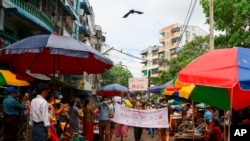 Demonstran anti kudeta membawa spanduk yang bertuliskan "Kami Mendukung NUG" yang merujuk pada kesatuan pemerintahan nasional dalam sebuah demonstrasi di Yangon, Myanmar, pada 17 April 2021. (Foto: Associated Press)