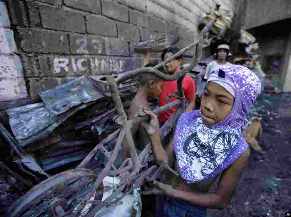 Seorang anak laki-laki, yang kehilangan rumahnya ketika terjadi kebakaran besar pada hari tahun baru, membawa sebuah sepeda yang terbakar di pinggiran kota Quezon city, Manila utara, Filipina. Kebakaran, yang diyakini dipicu oleh petasan itu, menghancurkan ratusan rumah pada hari Kamis, dan merupakan salah satu dari belasan kebakaran yang dilaporkan terjadi di seluruh Filipina ketika warga negara itu menyambut tahun baru. &nbsp;