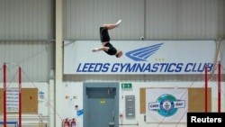 Ashley Watson, 29, from UK, attempts to set a new Guinness World Record for the "Farthest backflip between horizontal bars" in Leeds, Britain, November 12, 2021. Courtesy of Guinness World Records 2021/Michael Bowles/Handout via REUTERS 