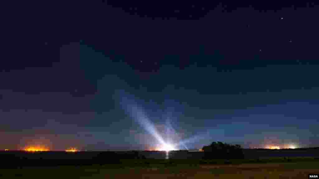 Le vaisseau spatial Orion de la NASA, accroché sur la fusée Launch Alliance Delta IV Heavy, est aperçu au loin, illuminé, dans cette photographie d'exposition prises tôt le jeudi 4 décembre 2014, au complexe de lancement spatial de Base de lancement de Cap Canaveral.
