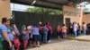 Familiares de pacientes con coronavirus esperan noticias de sus familiares fuera de un centro de salud en Managua, Nicaragua.