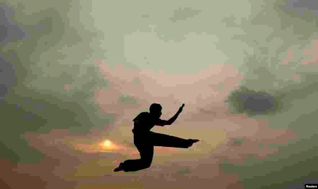 Siluet seorang anak berlatih karate di pantai di Kolombo, Sri Lanka.