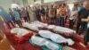 Kerabat dan para pelayat berdiri di samping jenazah lima anak keluarga Abu Dagga yang tewas dalam serangan udara Israel pada pemakaman mereka di Khan Younis, Jalur Gaza selatan, Sabtu, 7 Oktober 2023. (AP /Yousef Masoud)