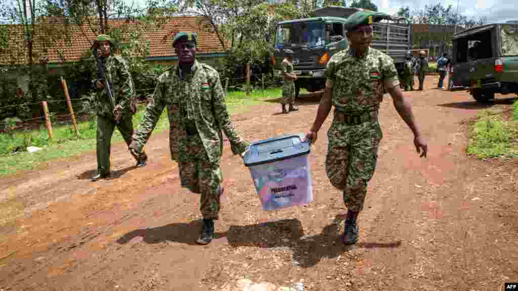 Des policiers kenyans transportent des urnes à l'école primaire olympique après que des habitants de Kibera aient tenté de bloquer le vote tôt le matin à Nairobi, le 26 octobre 2017.