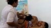 FILE - A nurse checks the blood pressure of patient Niurka Rodriguez, who is eight months pregnant at a government run neighborhood clinic in Havana, Cuba, Aug 16, 2012.