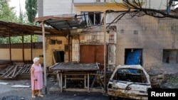 FILE - A woman walks at a site of a recent shelling, which local Russian-installed authorities called a Ukrainian military strike, in the course of Russia-Ukraine conflict in Donetsk, Russian-controlled Ukraine, July 22, 2024.