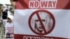 A child stands next to an anti-Lady Gaga banner in Jakarta April 29, 2012.