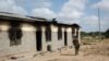 A member of Kenya's security forces walks past a damaged police post after an attack by al-Shabab extremists in the settlement of Kamuthe in Garissa County, Kenya, Jan. 13, 2020. 