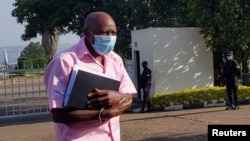 Paul Rusesabagina, akitembea amefungwa pingu akielekea mahakamani mjini Kigali, Februari 26, 2021.